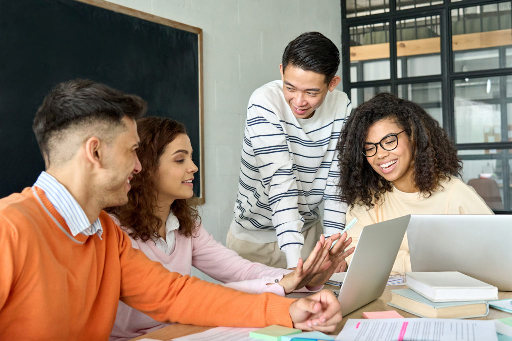 a group of people looking at a laptop