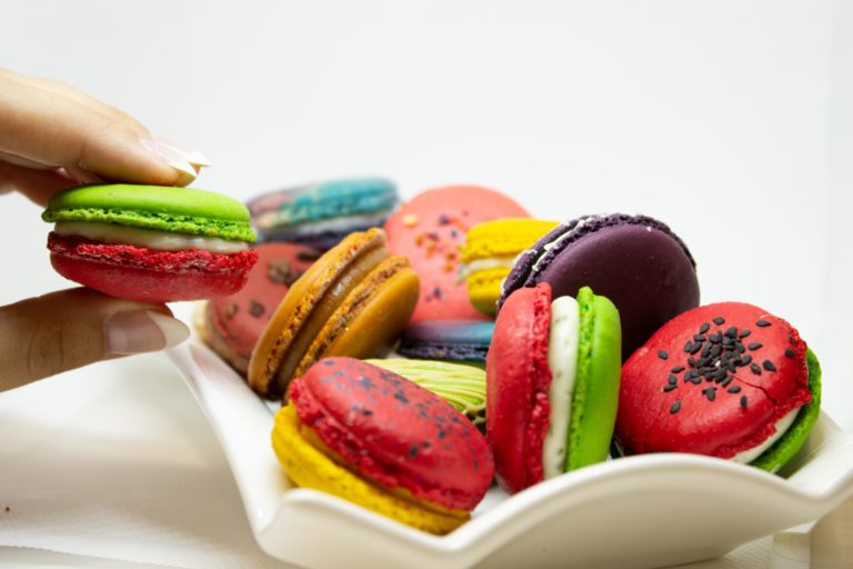 a hand holding a bowl of colorful candies