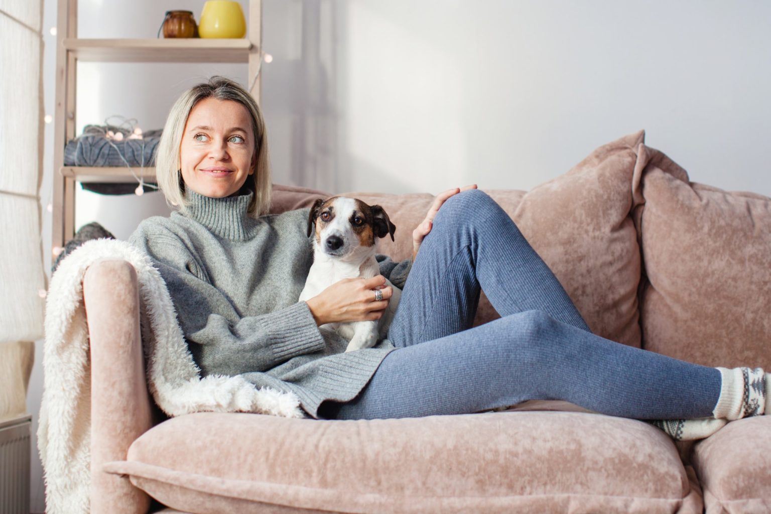 a person sitting on a couch holding a dog
