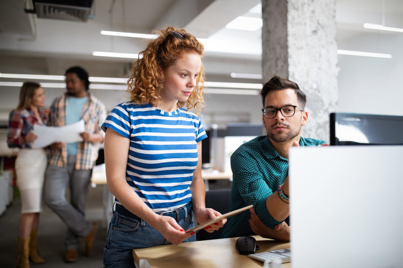 a man and woman looking at a computer screen