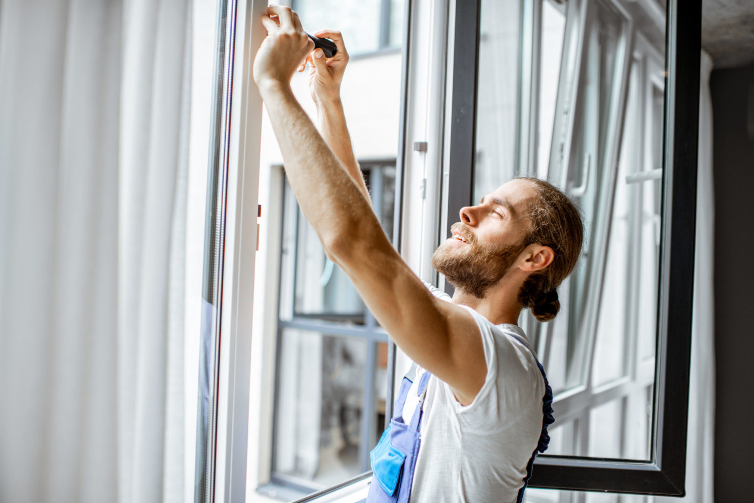 HANDYMAN INSTALLING A WINDOW