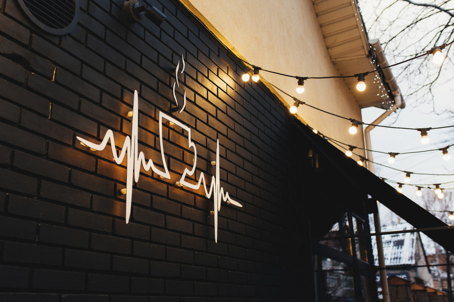 Coffee symbol on black brick wall with garlands